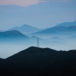 Linhas de transmissão elétrica diante de montanhas ao entardecer em Lima, no Peru.