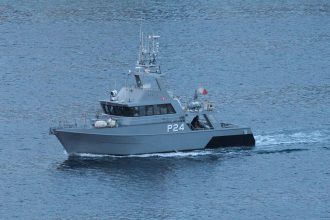 Embarcação militar patrulha águas abertas no oceano.