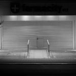 Farmácia fechada em Córdoba, na Argentina, fotografada à noite em preto e branco.