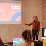 Mulher apresenta conceitos de evolução digital, inteligência artificial e big data durante um seminário.