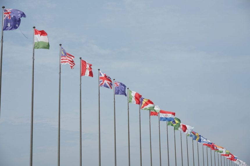Fileira de bandeiras internacionais hasteadas, representando relações diplomáticas e cooperação entre países.