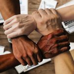 Grupo diverso de profissionais reunido em um ambiente de trabalho, representando colaboração e participação institucional.