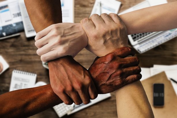 Grupo diverso de profissionais reunido em um ambiente de trabalho, representando colaboração e participação institucional.